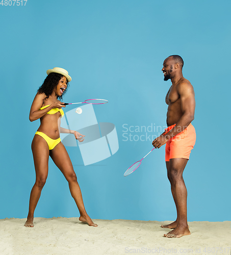 Image of Happy young couple resting on blue studio background