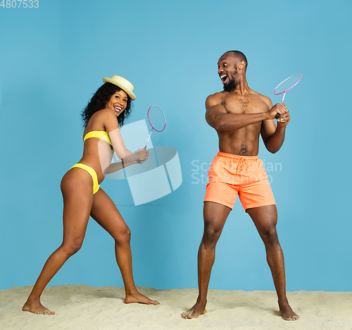 Image of Happy young couple resting on blue studio background