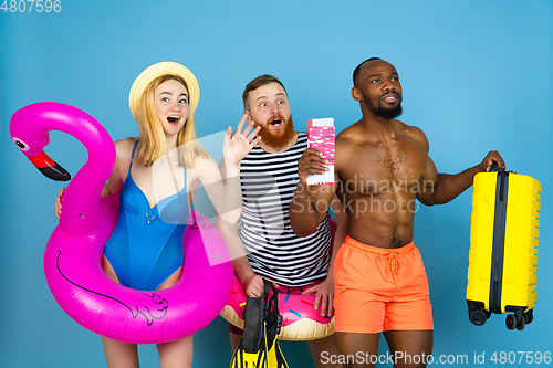 Image of Happy young friends resting on blue studio background