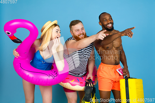 Image of Happy young friends resting on blue studio background