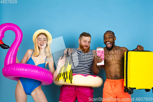 Image of Happy young friends resting on blue studio background