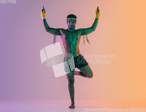 Image of Muay thai. Young man exercising thai boxing on gradient background