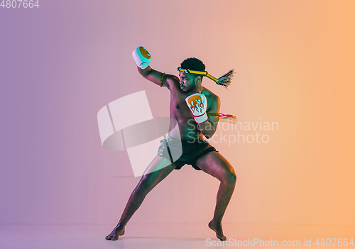 Image of Muay thai. Young man exercising thai boxing on gradient background