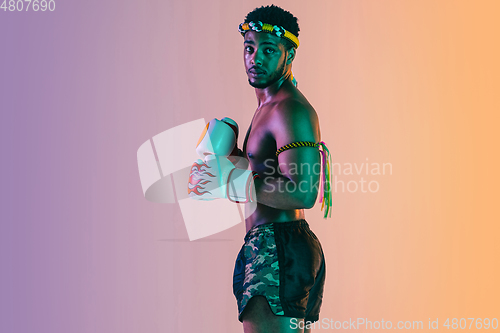 Image of Muay thai. Young man exercising thai boxing on gradient background