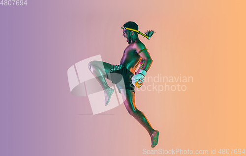 Image of Muay thai. Young man exercising thai boxing on gradient background