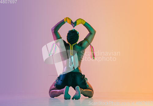 Image of Muay thai. Young man exercising thai boxing on gradient background