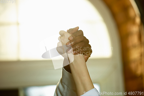 Image of Close up of african-american and caucasian human\'s hands gesturing