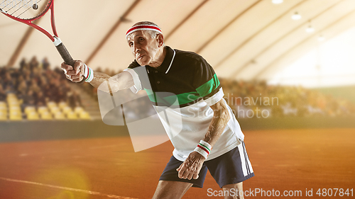 Image of Senior man playing tennis in sportwear on stadium