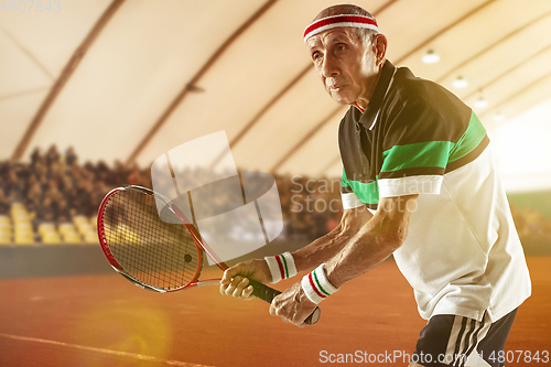 Image of Senior man playing tennis in sportwear on stadium