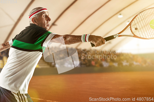 Image of Senior man playing tennis in sportwear on stadium