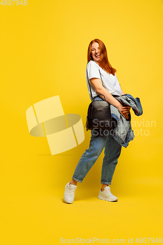 Image of Caucasian woman\'s portrait isolated on yellow studio background, follower be like