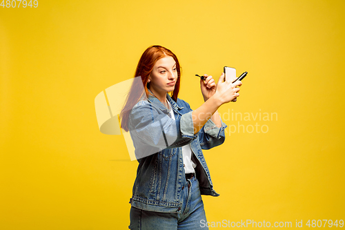 Image of Caucasian woman\'s portrait isolated on yellow studio background, follower be like