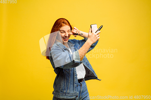 Image of Caucasian woman\'s portrait isolated on yellow studio background, follower be like