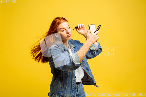 Image of Caucasian woman\'s portrait isolated on yellow studio background, follower be like