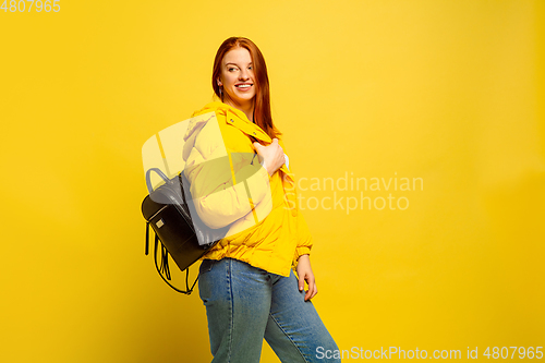 Image of Caucasian woman\'s portrait isolated on yellow studio background, follower be like