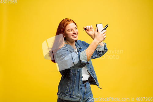 Image of Caucasian woman\'s portrait isolated on yellow studio background, follower be like