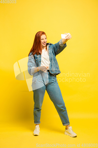 Image of Caucasian woman\'s portrait isolated on yellow studio background, follower be like