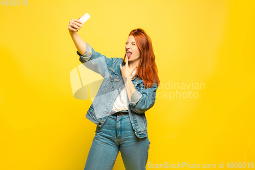 Image of Caucasian woman\'s portrait isolated on yellow studio background, follower be like