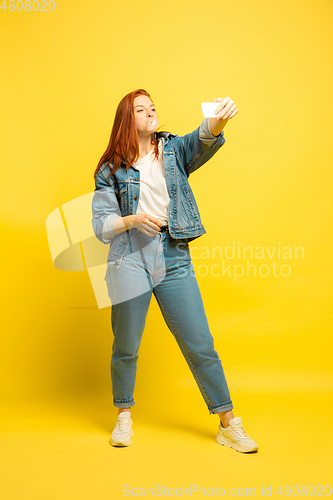 Image of Caucasian woman\'s portrait isolated on yellow studio background, follower be like