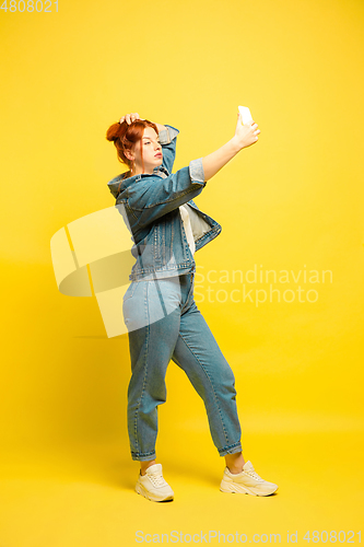 Image of Caucasian woman\'s portrait isolated on yellow studio background, follower be like