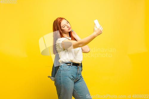 Image of Caucasian woman\'s portrait isolated on yellow studio background, follower be like