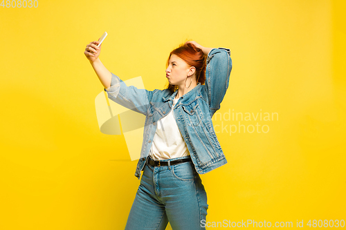 Image of Caucasian woman\'s portrait isolated on yellow studio background, follower be like