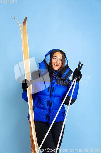 Image of Caucasian woman\'s portrait isolated on blue studio background, winter theme