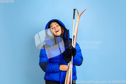 Image of Caucasian woman\'s portrait isolated on blue studio background, winter theme