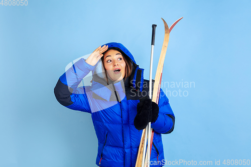 Image of Caucasian woman\'s portrait isolated on blue studio background, winter theme