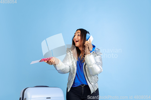 Image of Caucasian woman\'s portrait isolated on blue studio background, winter theme