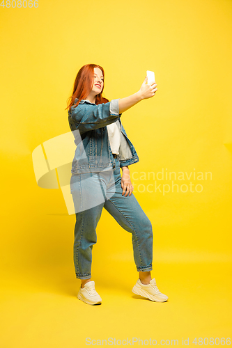 Image of Caucasian woman\'s portrait isolated on yellow studio background, follower be like