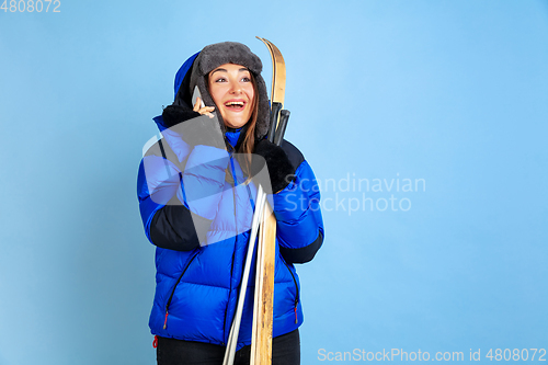 Image of Caucasian woman\'s portrait isolated on blue studio background, winter theme