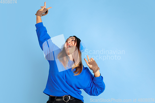 Image of Caucasian woman\'s portrait isolated on blue studio background, winter theme