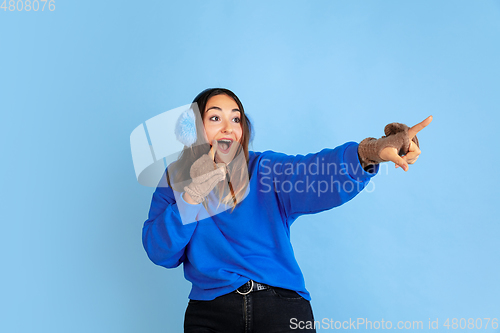 Image of Caucasian woman\'s portrait isolated on blue studio background, winter theme