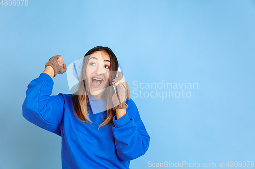 Image of Caucasian woman\'s portrait isolated on blue studio background, winter theme