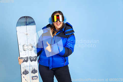 Image of Caucasian woman\'s portrait isolated on blue studio background, winter theme