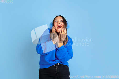 Image of Caucasian woman\'s portrait isolated on blue studio background, winter theme