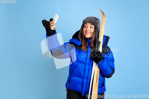 Image of Caucasian woman\'s portrait isolated on blue studio background, winter theme