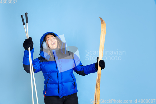 Image of Caucasian woman\'s portrait isolated on blue studio background, winter theme