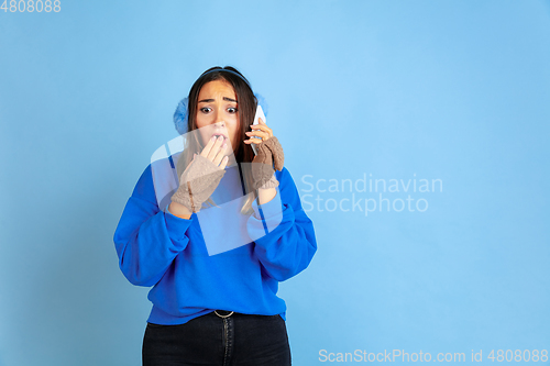 Image of Caucasian woman\'s portrait isolated on blue studio background, winter theme