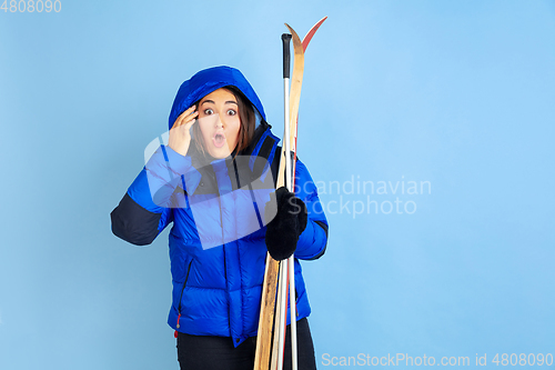 Image of Caucasian woman\'s portrait isolated on blue studio background, winter theme