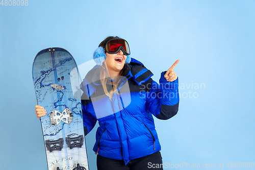 Image of Caucasian woman\'s portrait isolated on blue studio background, winter theme