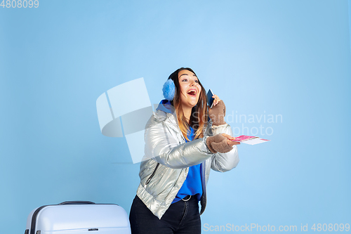 Image of Caucasian woman\'s portrait isolated on blue studio background, winter theme