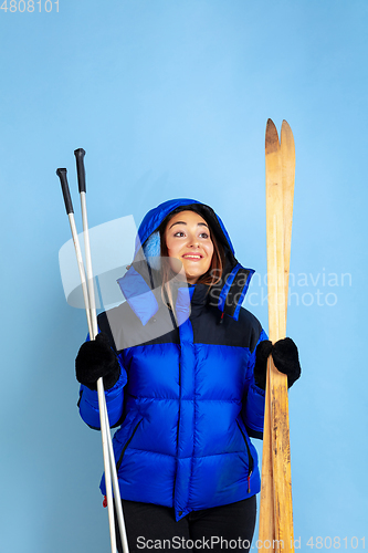 Image of Caucasian woman\'s portrait isolated on blue studio background, winter theme