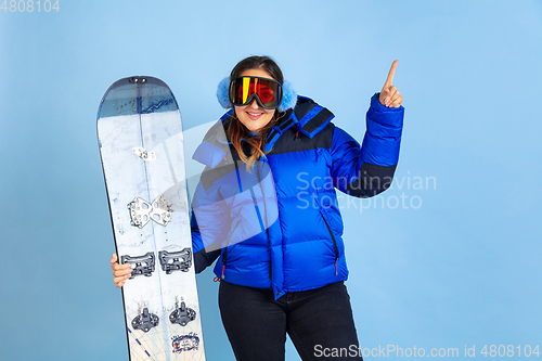 Image of Caucasian woman\'s portrait isolated on blue studio background, winter theme