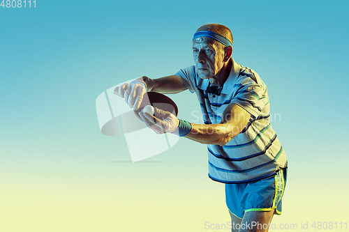 Image of Senior man playing table tennis in sportwear on gradient background and neon light