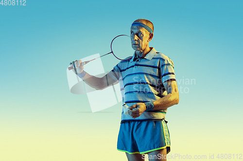 Image of Senior man playing volleyball in sportwear on gradient background and neon light