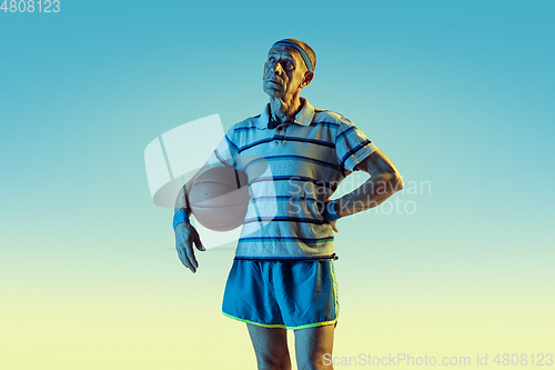 Image of Senior man playing basketball in sportwear on gradient background and neon light