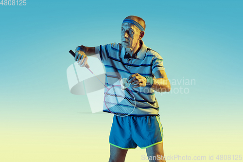 Image of Senior man playing volleyball in sportwear on gradient background and neon light