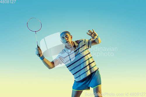 Image of Senior man playing volleyball in sportwear on gradient background and neon light